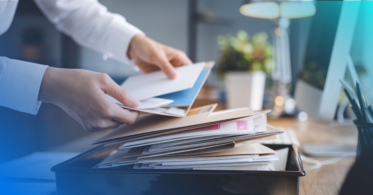 Person handling large tray of incoming mail 