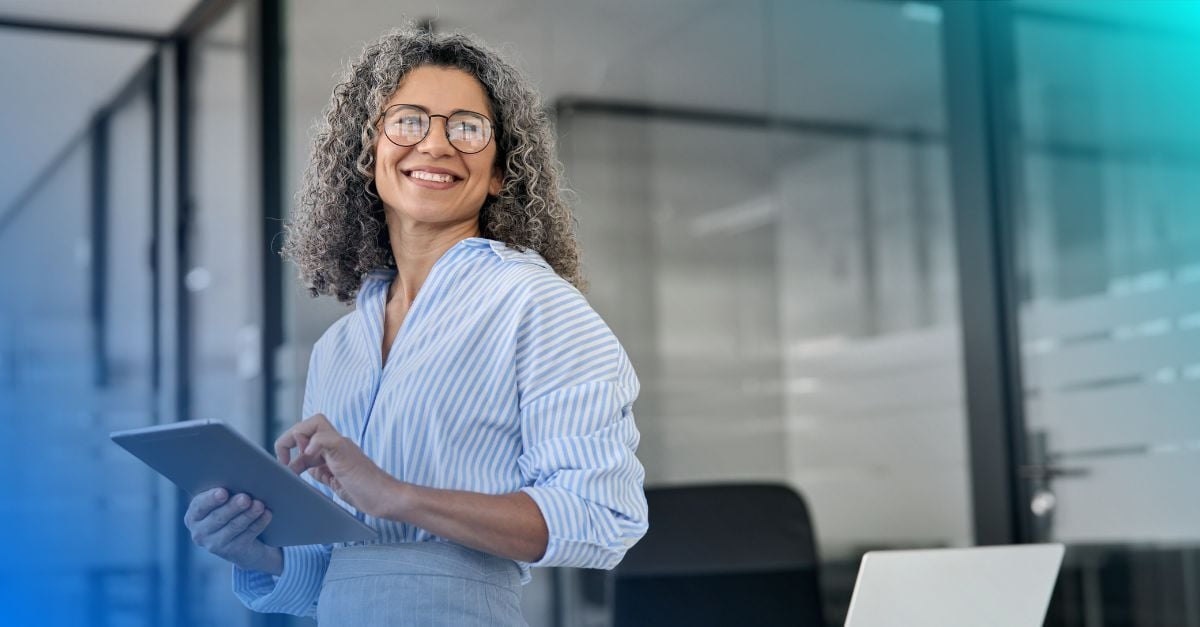 Smiling woman holding tablet in professional office
